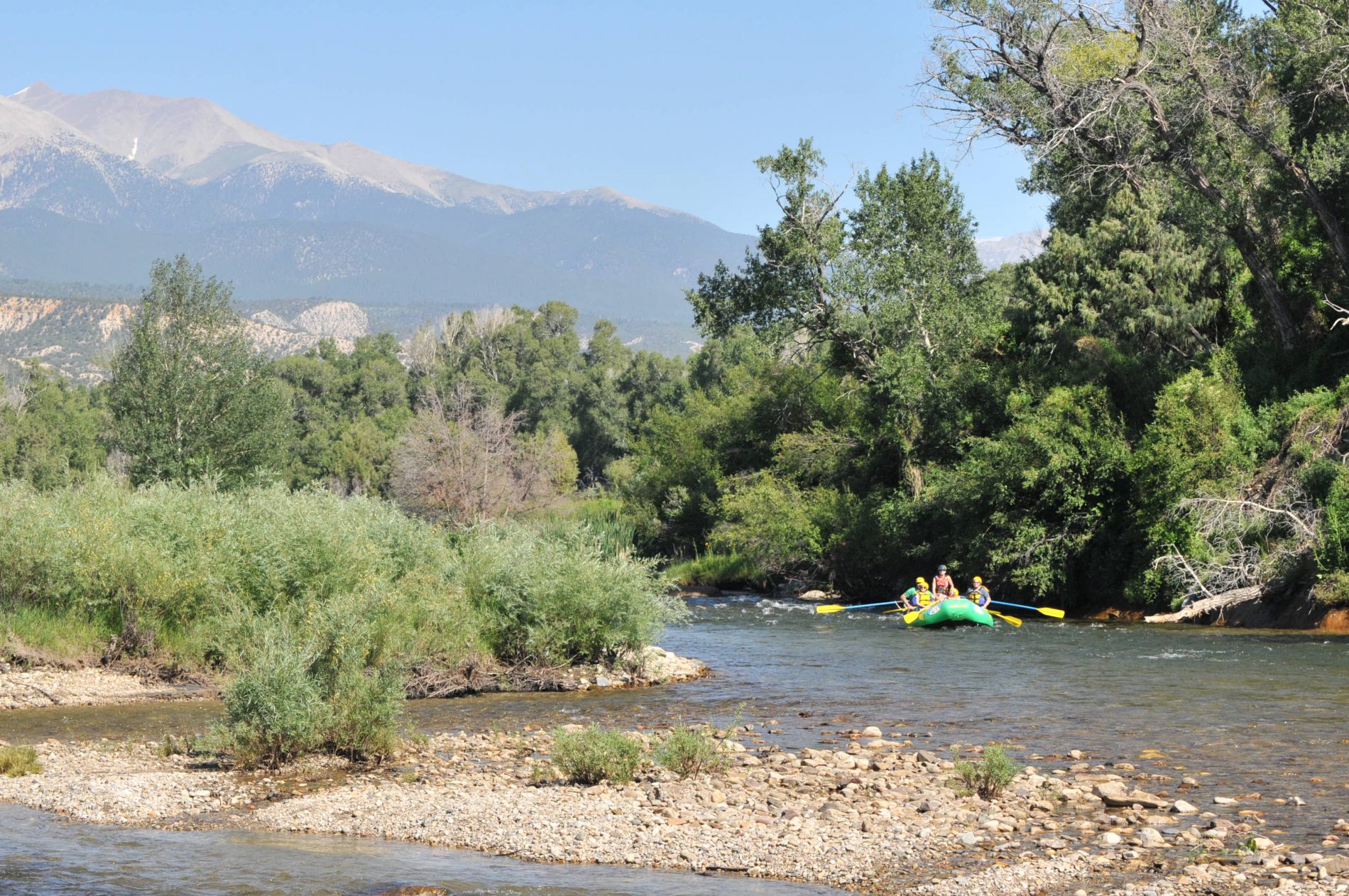 Rafters paddle through calm water on the river