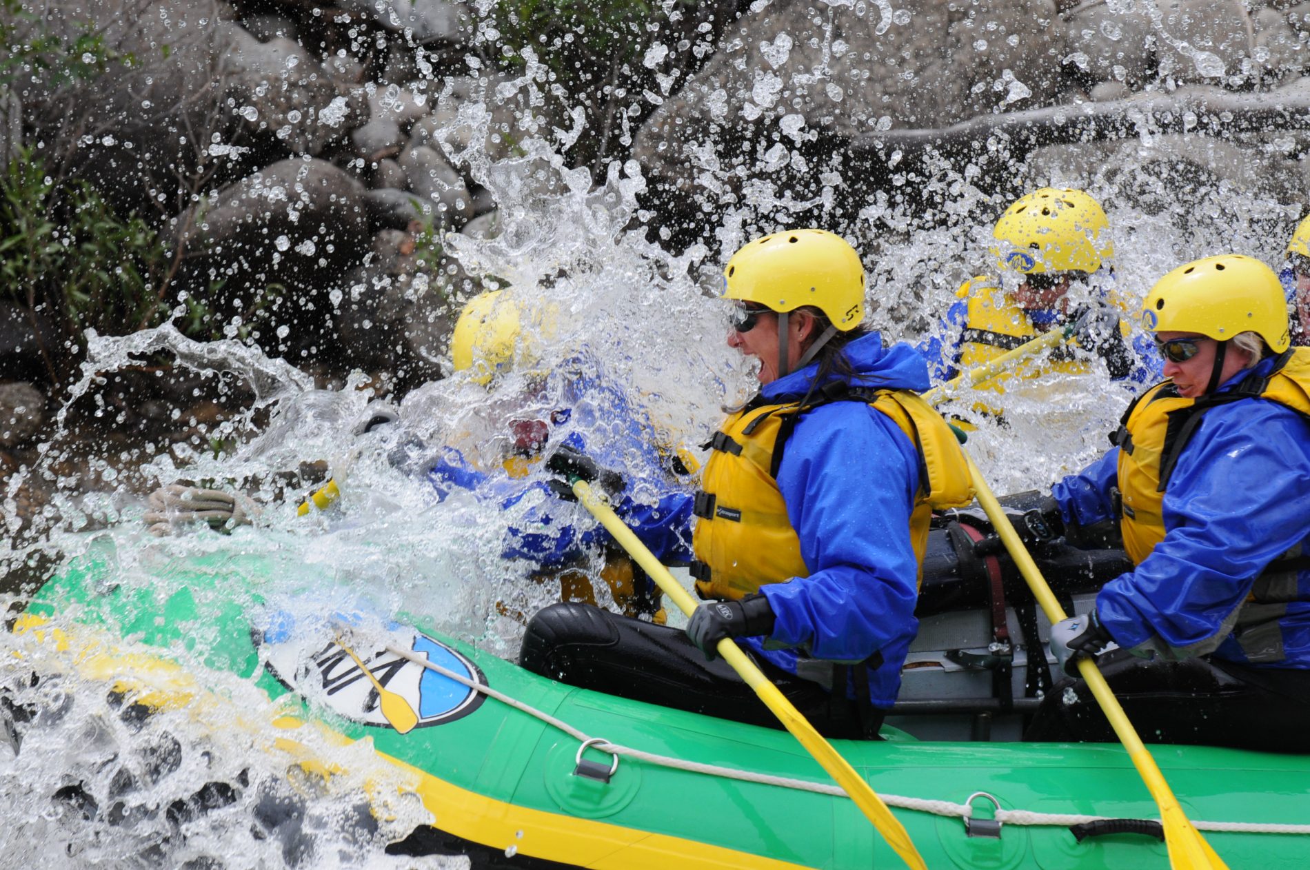 Group of rafters take water to the face going through rapids