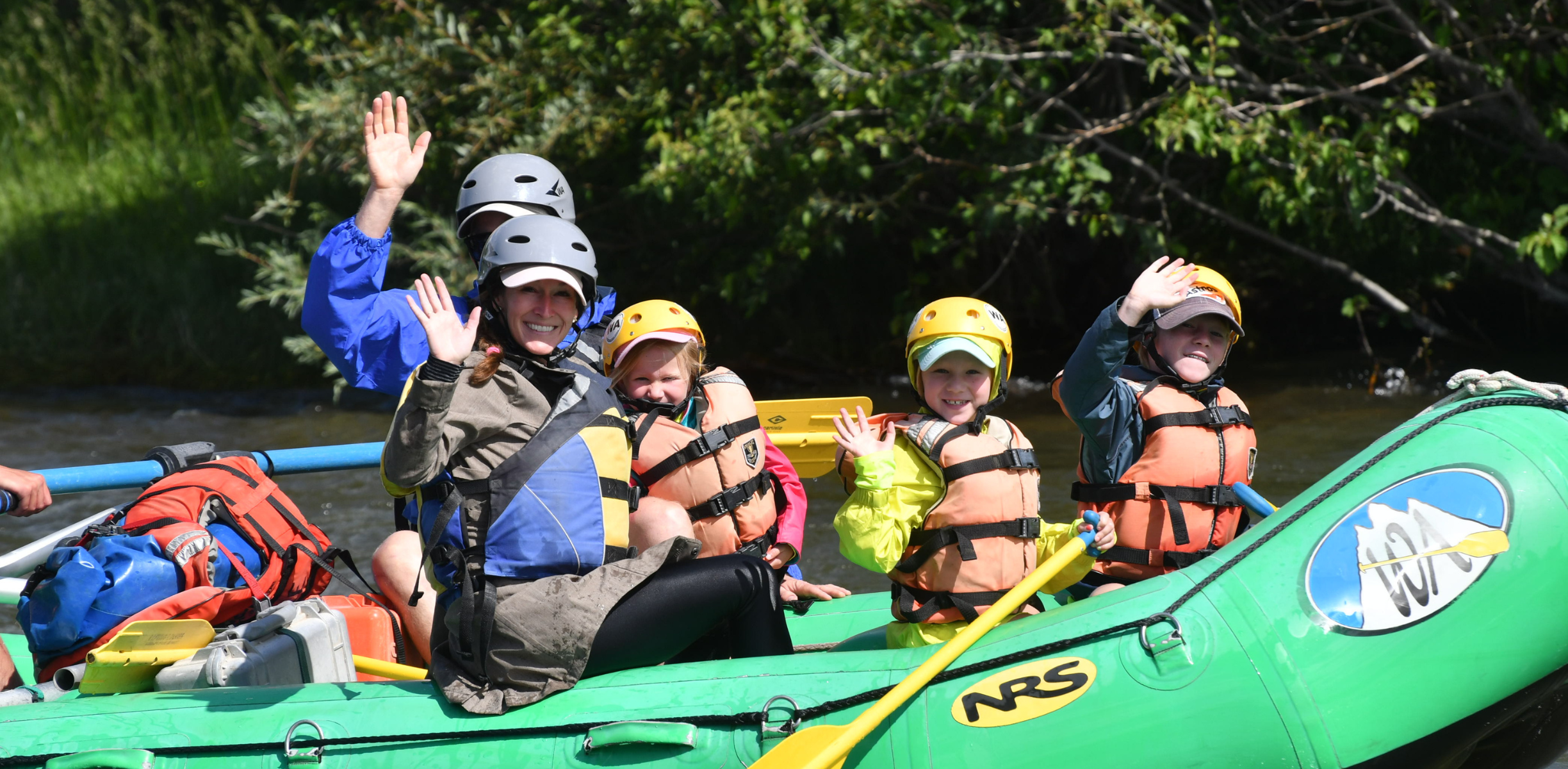 A family with two kids on a green raft in colorado