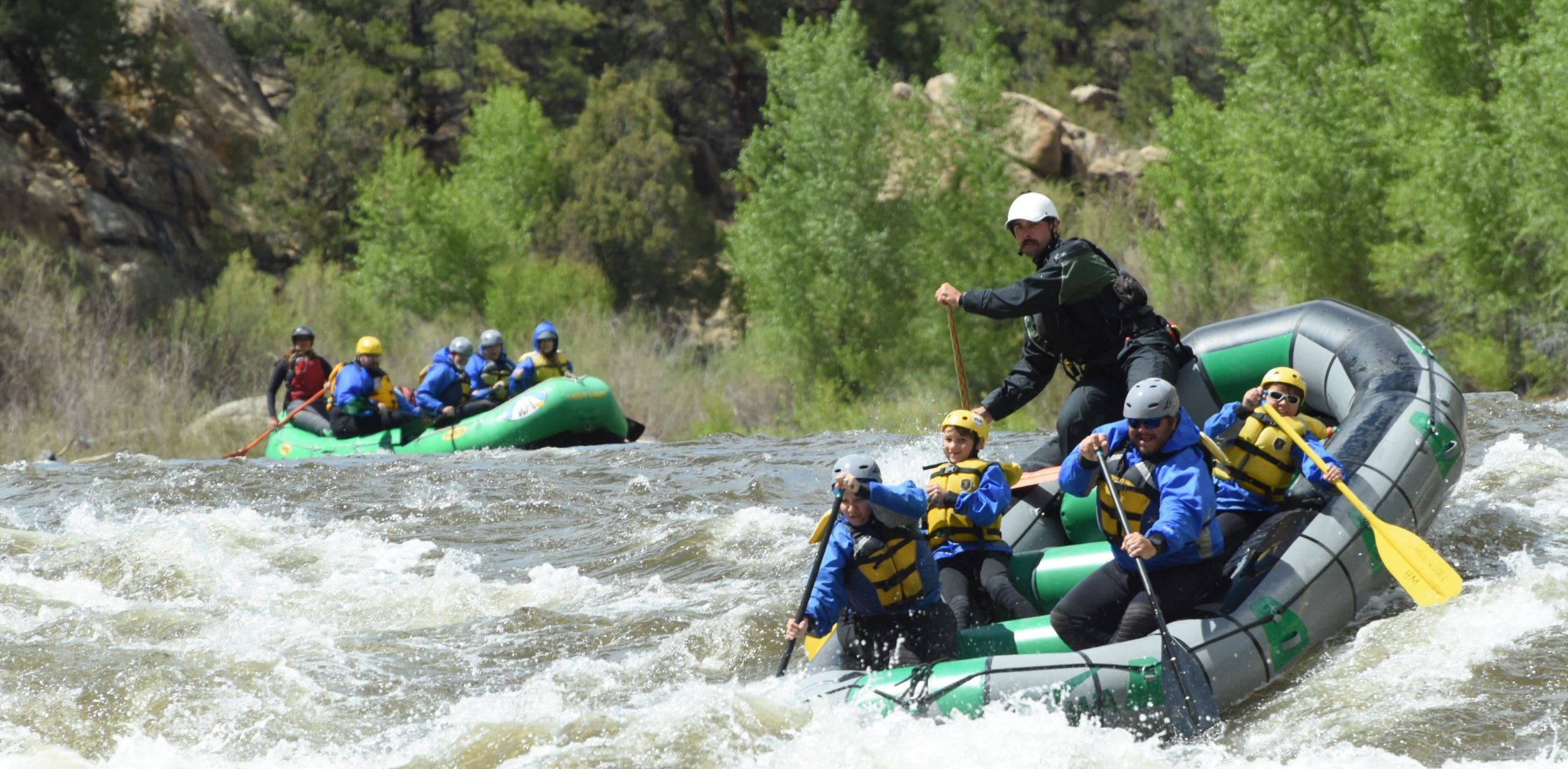 Two rafting groups paddling into rapids on a Browns Canyon river rafting trip.