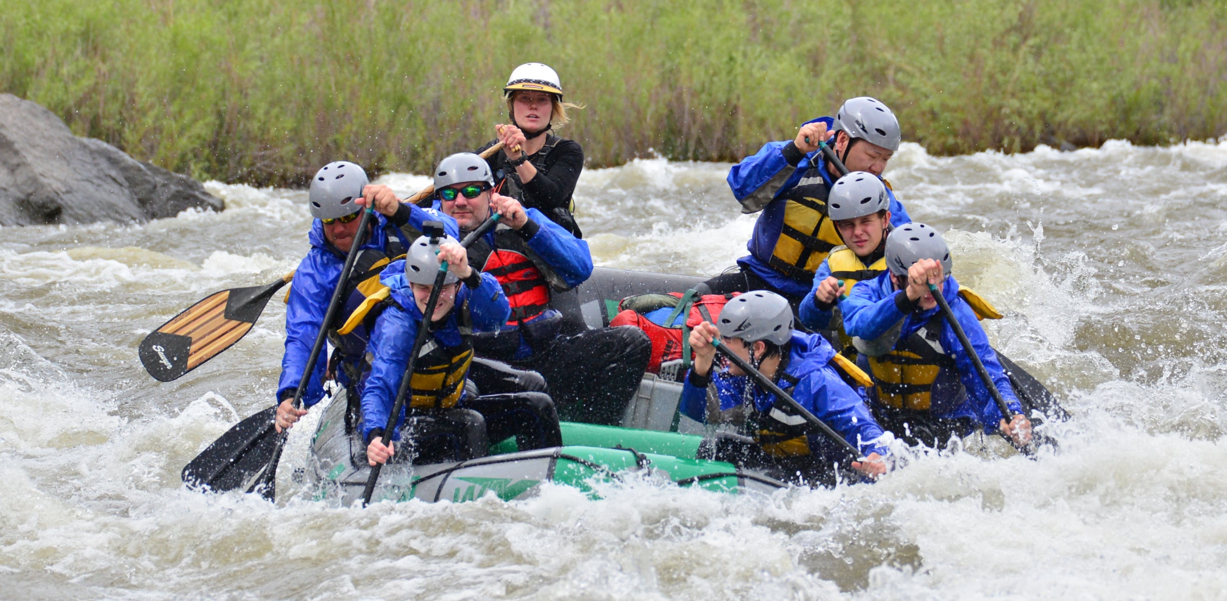 White water rafters paddling through rapids