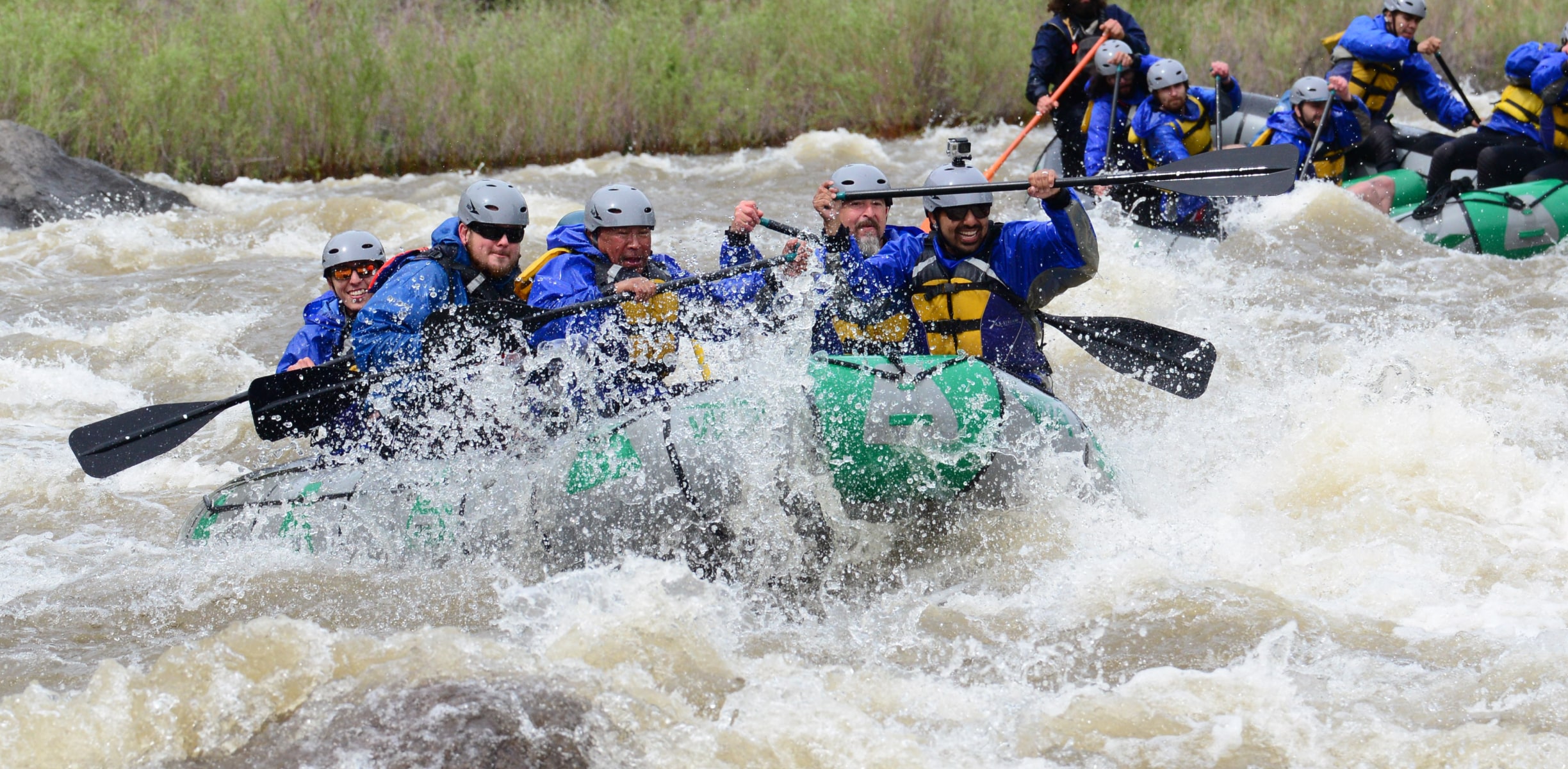 Group of rafters paddling through rapids on the Arkansas River in Colorado.