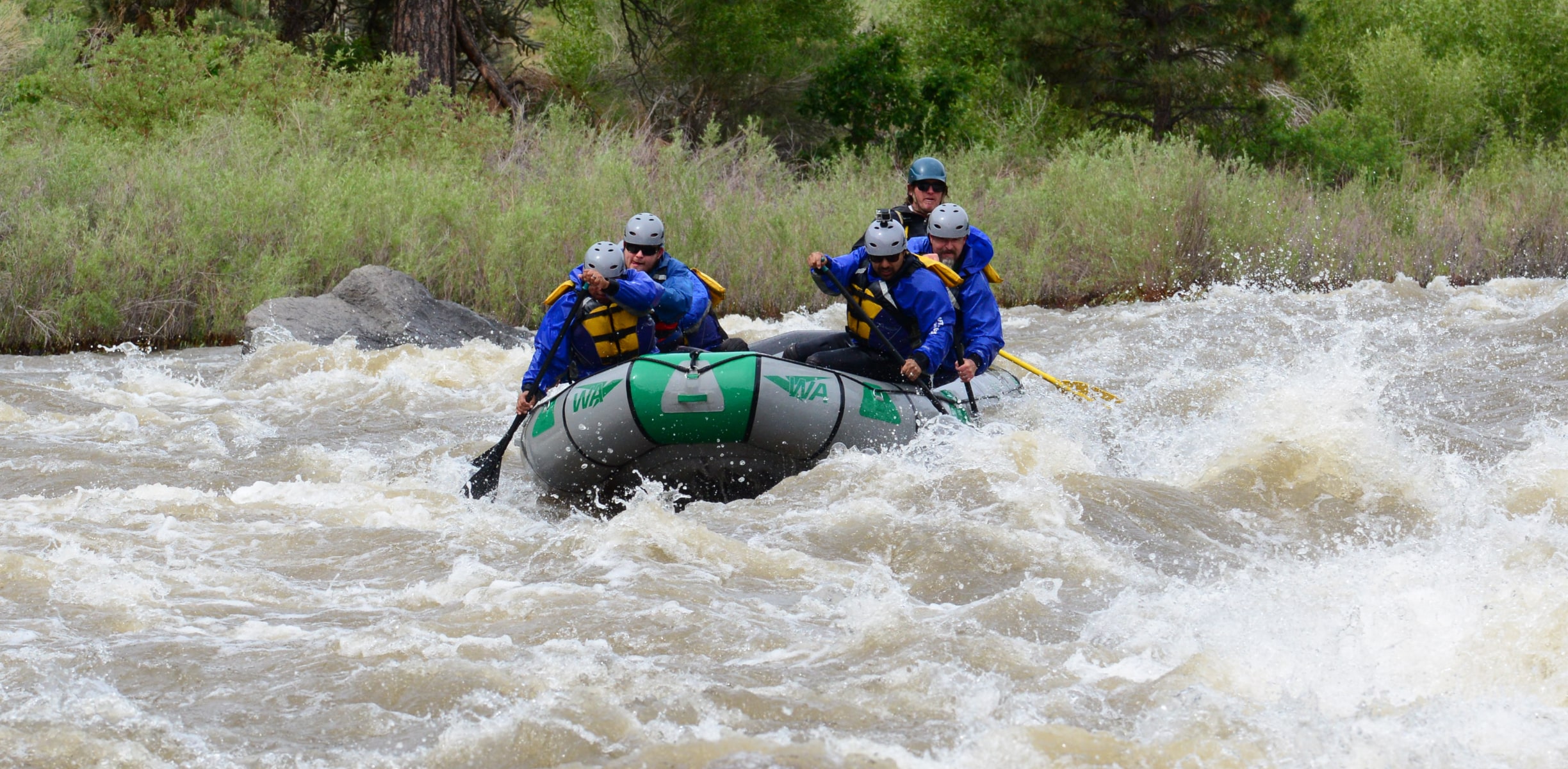 Group of rafters paddling through rapids on the Arkansas River in Colorado.