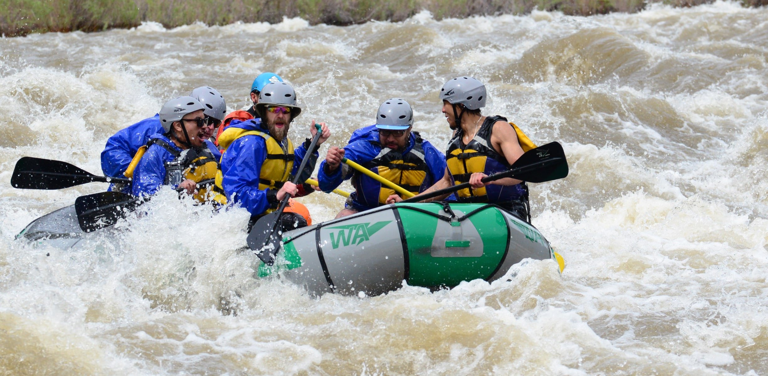 Group of rafters paddling through rapids on the Arkansas River in Colorado.