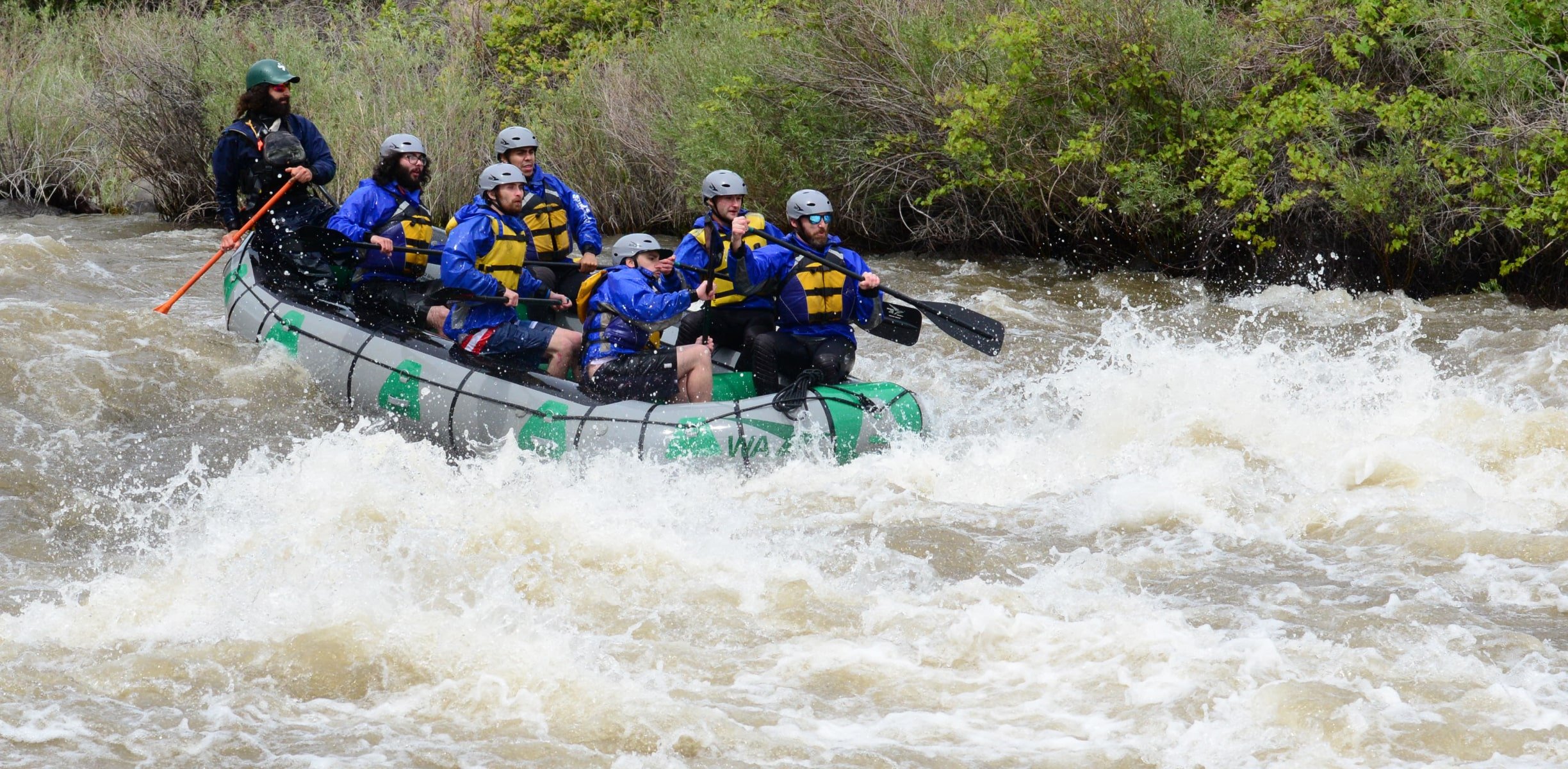 A group about to hit a set of rapids during a colorado rafting trip