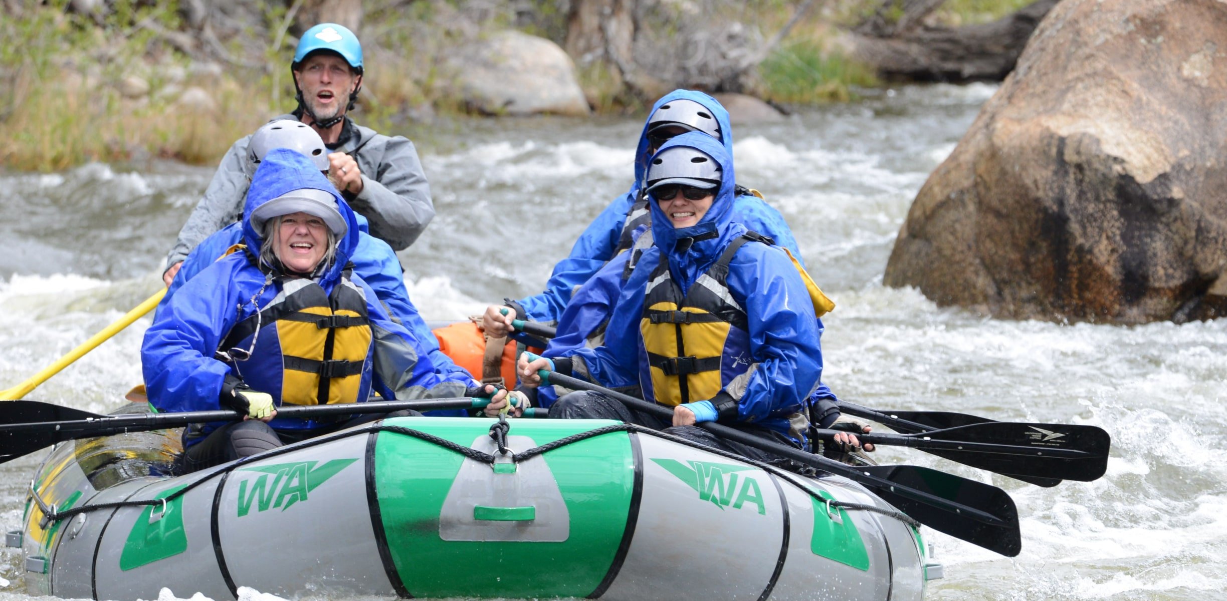 People smiling in a whitewater raft