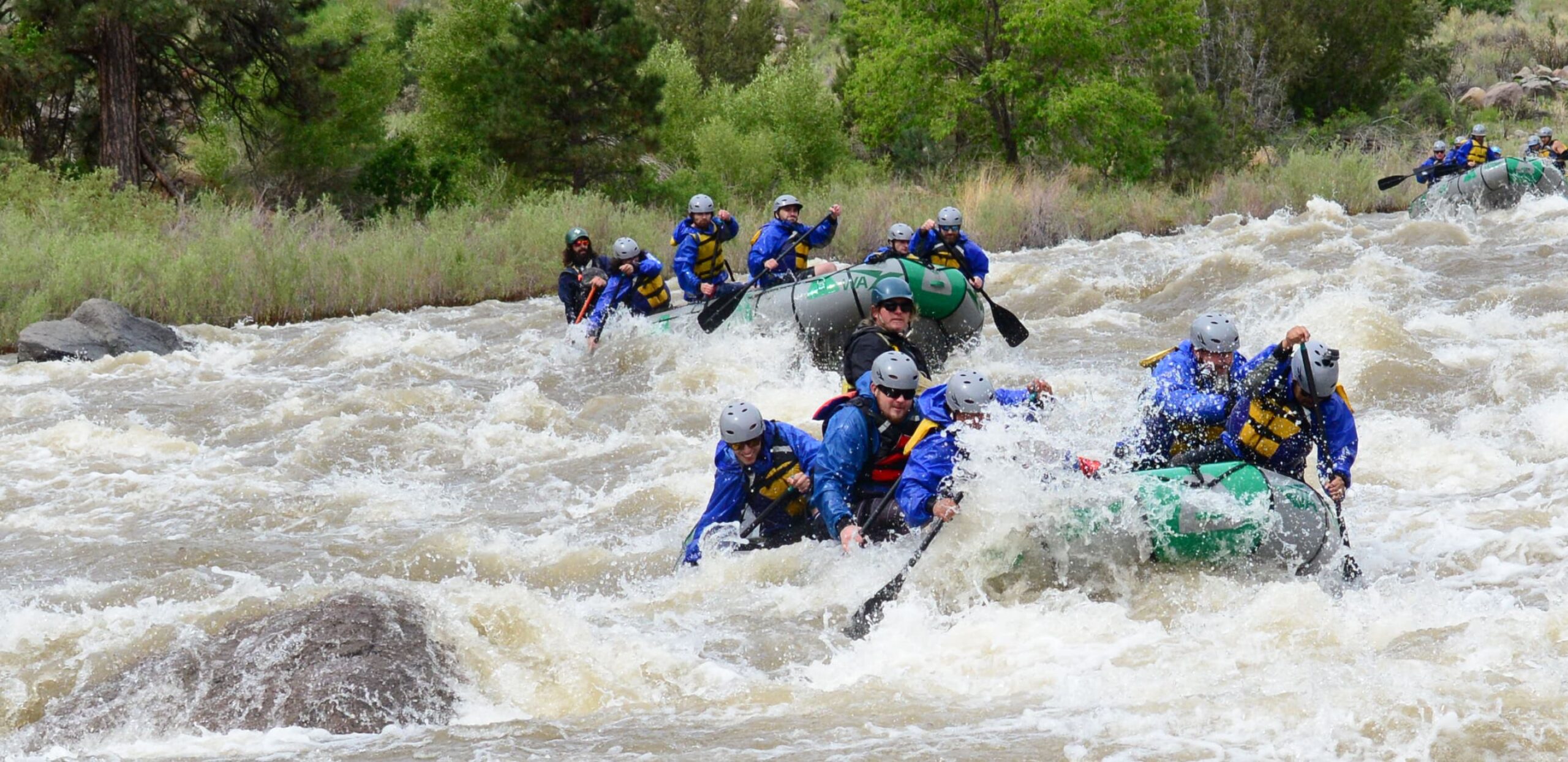 Three rafts hitting rapids in whitewater