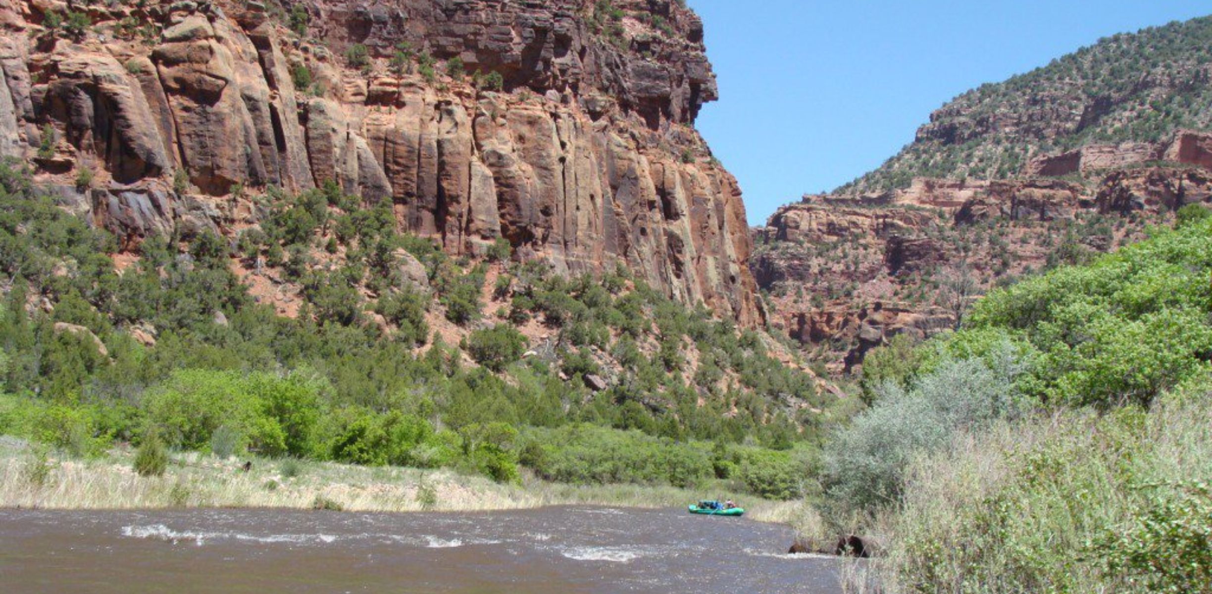 The Dolores River flows between red rock canyon walls