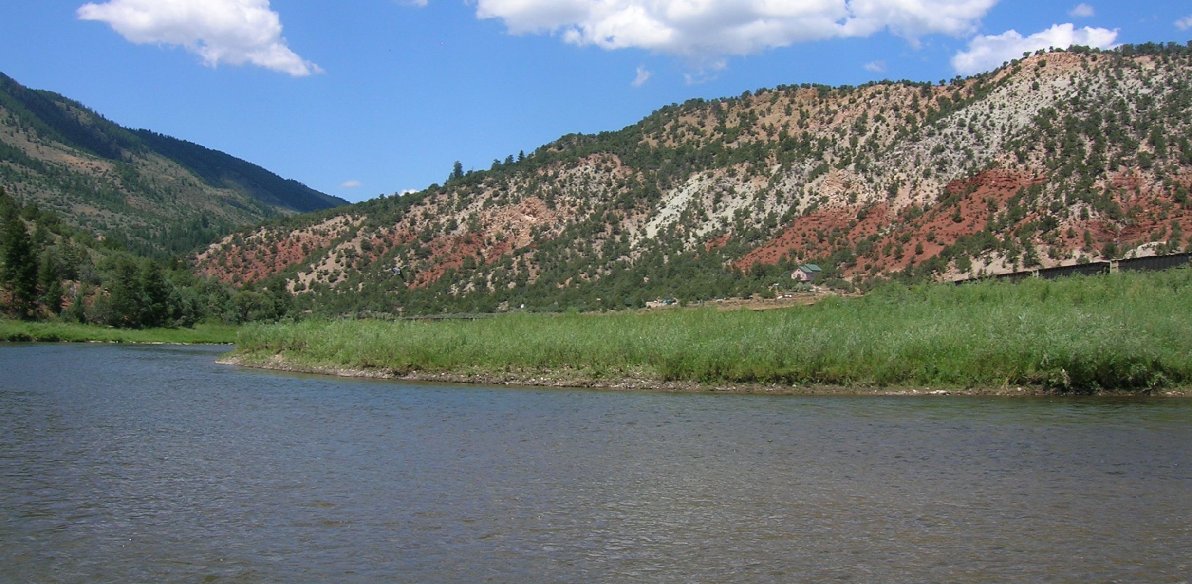 The river in kremmling, colorado with grass on the shore