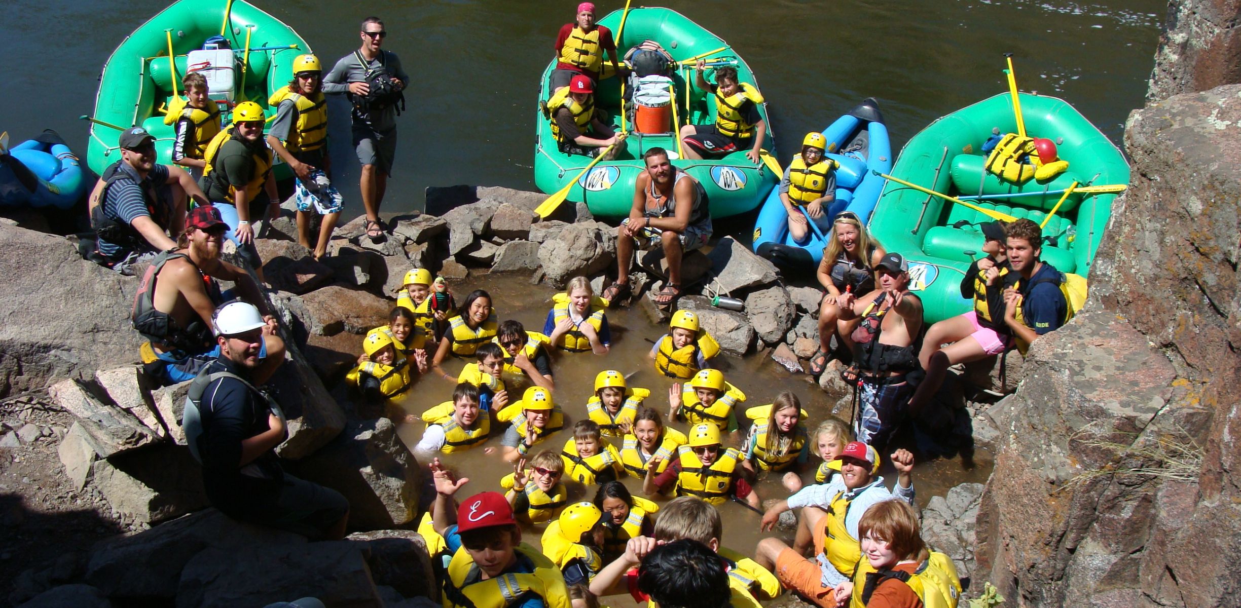 People on a raft trip stop to soak in a natural hot springs