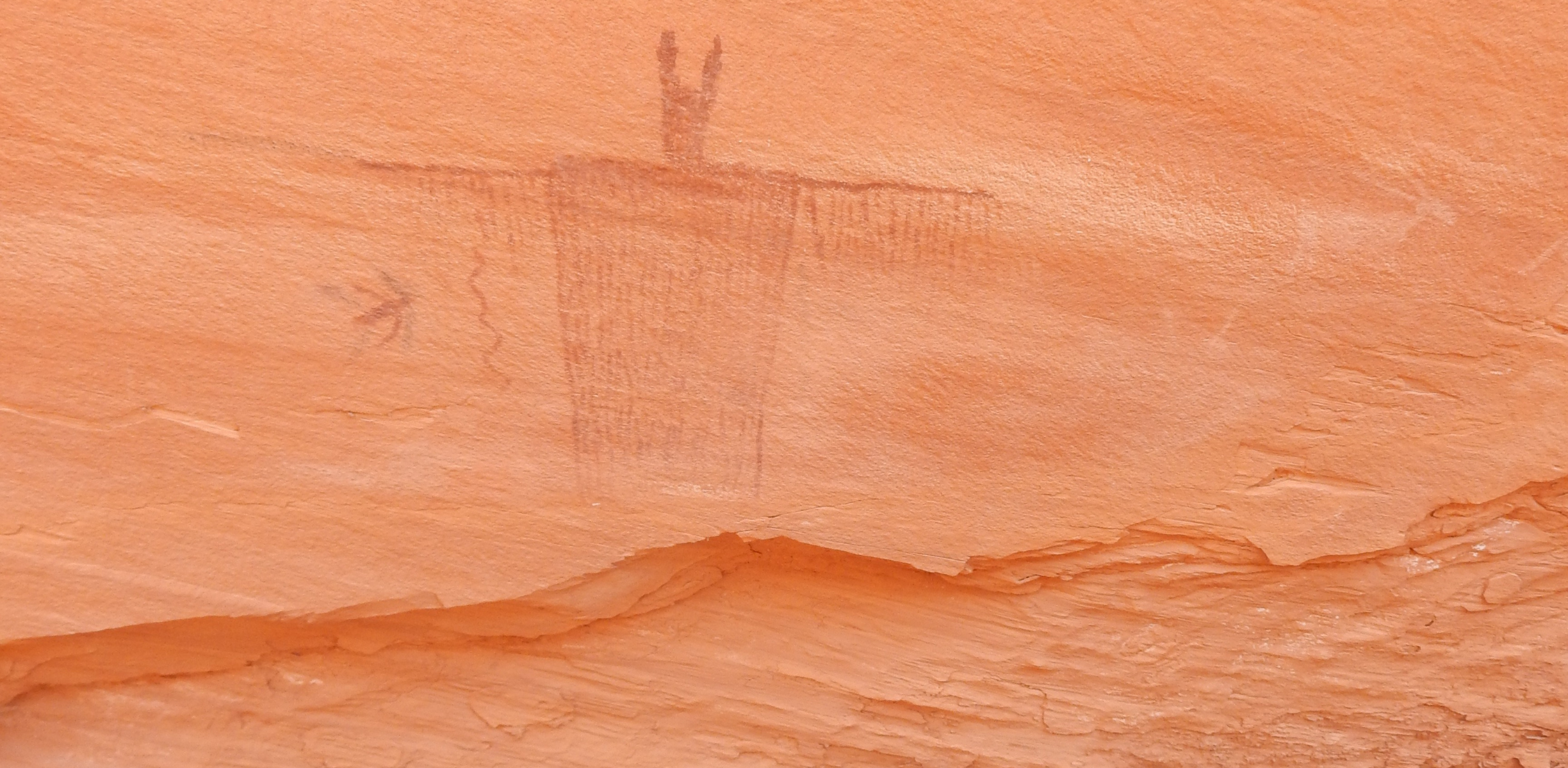 a petroglyph scribed into a red rock in the desert