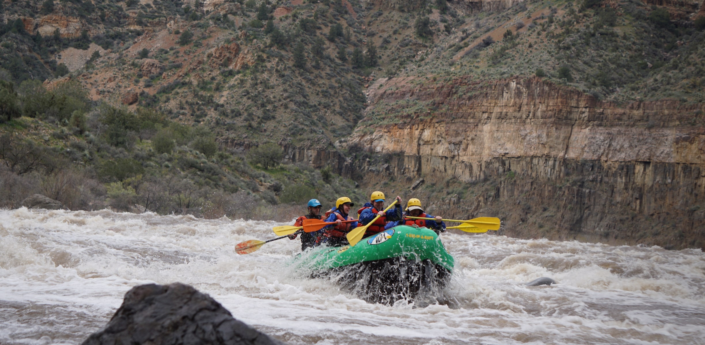 A group of white water rafters hitting a set of rapids in Arizona