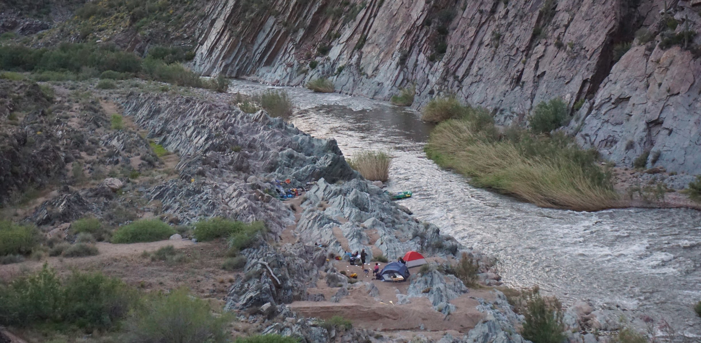 People camping with tents on the riverside of a river in Arizona