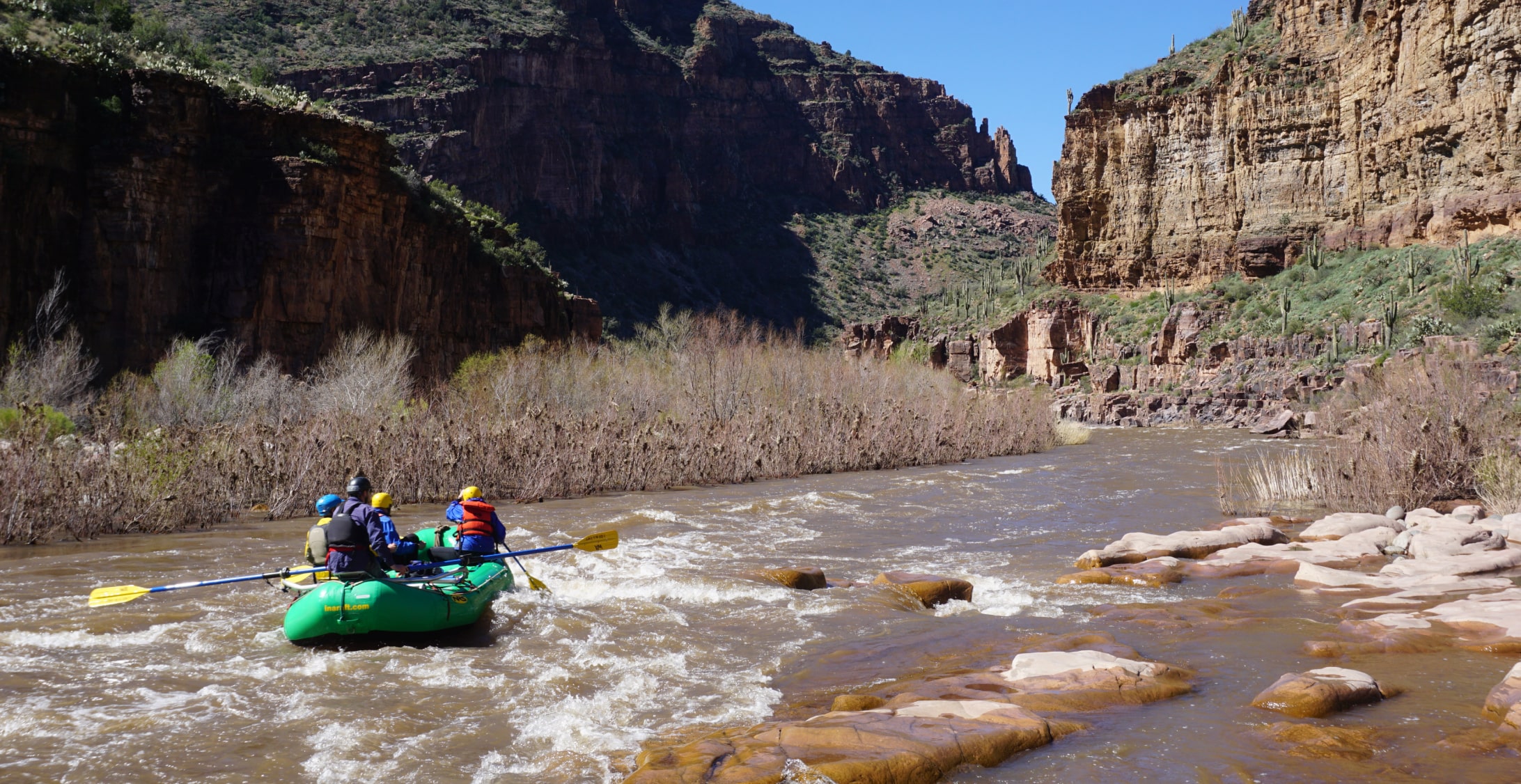 A group of rafters paddling a scenic river canyon in Arizona