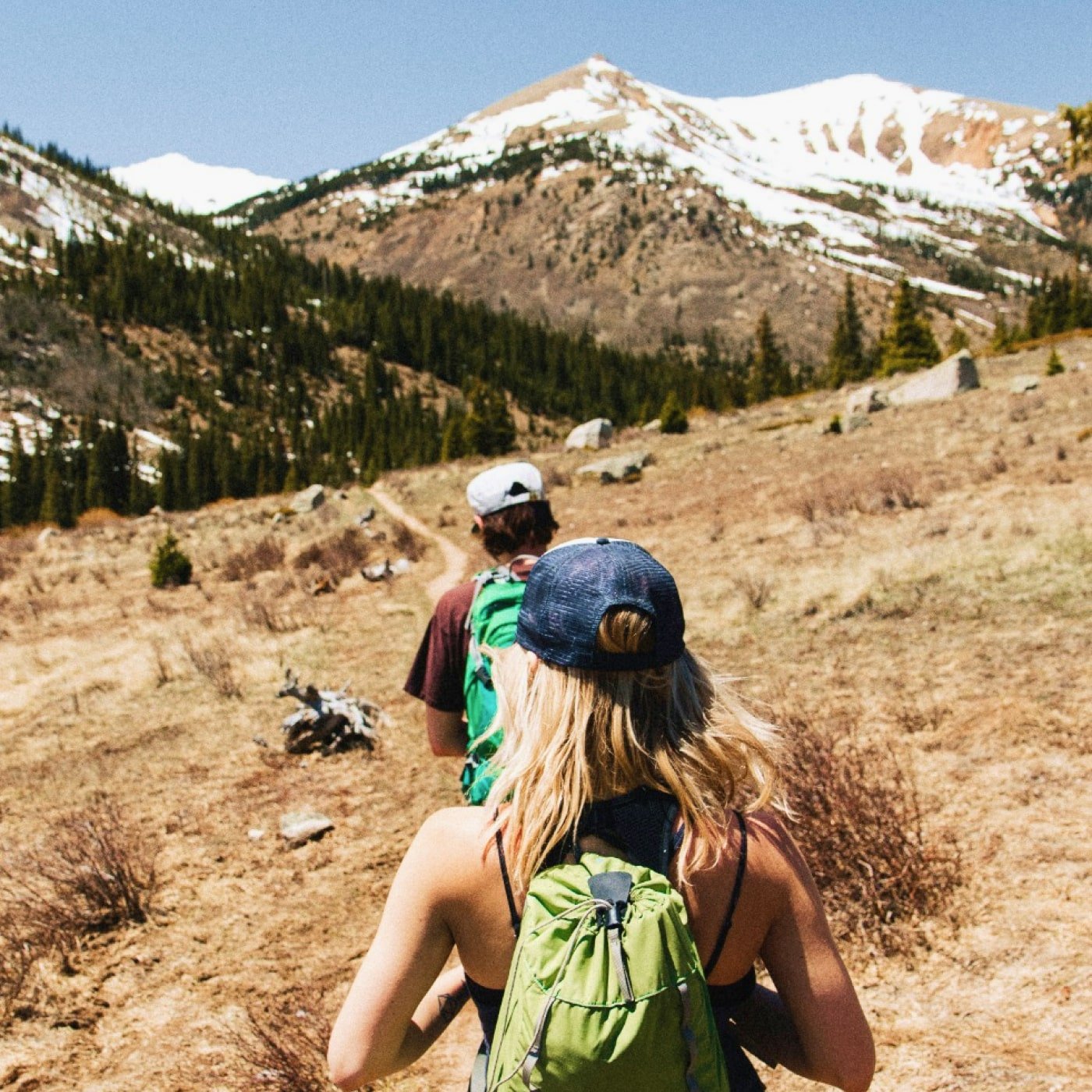 People hiking on a trail in Buena Vista with snow capped peaks in the distance