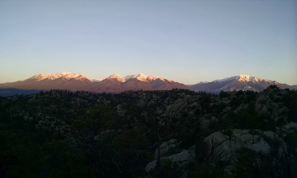 Panoramic view of the Browns Canyon monument with snowcapped mountains in the background, highlighting the breathtaking scenery encountered during rafting trips on the Arkansas River in Colorado.