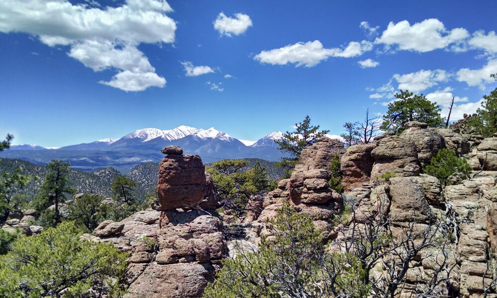 Panoramic view of the Browns Canyon monument with snowcapped mountains in the background, highlighting the breathtaking scenery encountered during rafting trips on the Arkansas River in Colorado.