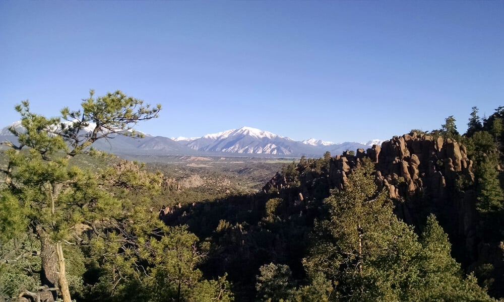 Panoramic view of the Browns Canyon monument with snowcapped mountains in the background, highlighting the breathtaking scenery encountered during rafting trips on the Arkansas River in Colorado.