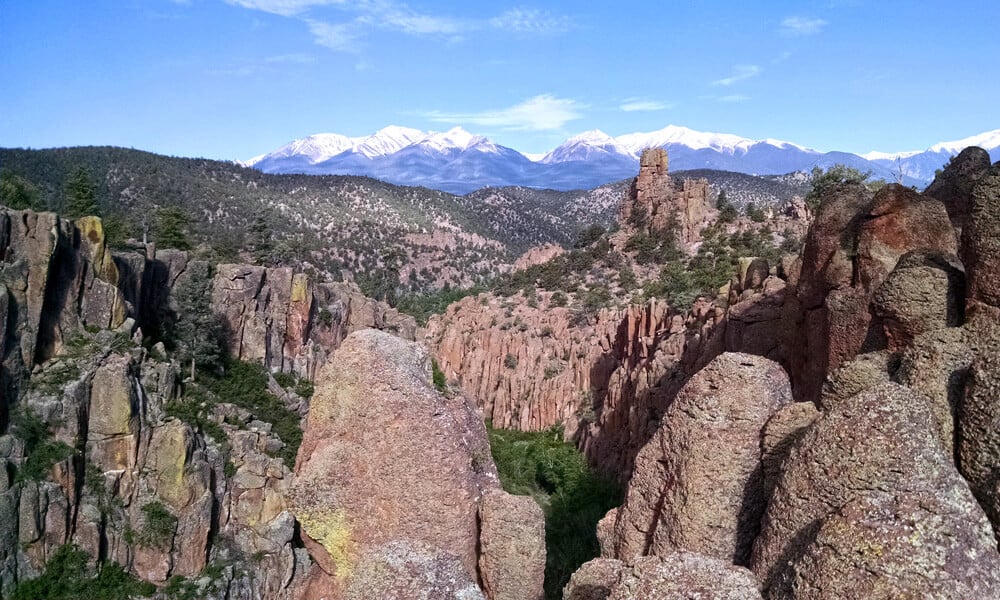 Panoramic view of the Browns Canyon monument with snowcapped mountains in the background, highlighting the breathtaking scenery encountered during rafting trips on the Arkansas River in Colorado.